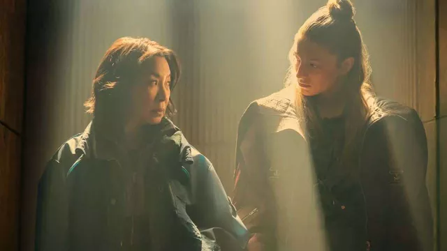 Deux personnages de Blade Runner 2099 échangent un regard dans une pièce éclairée d’une lumière dorée.